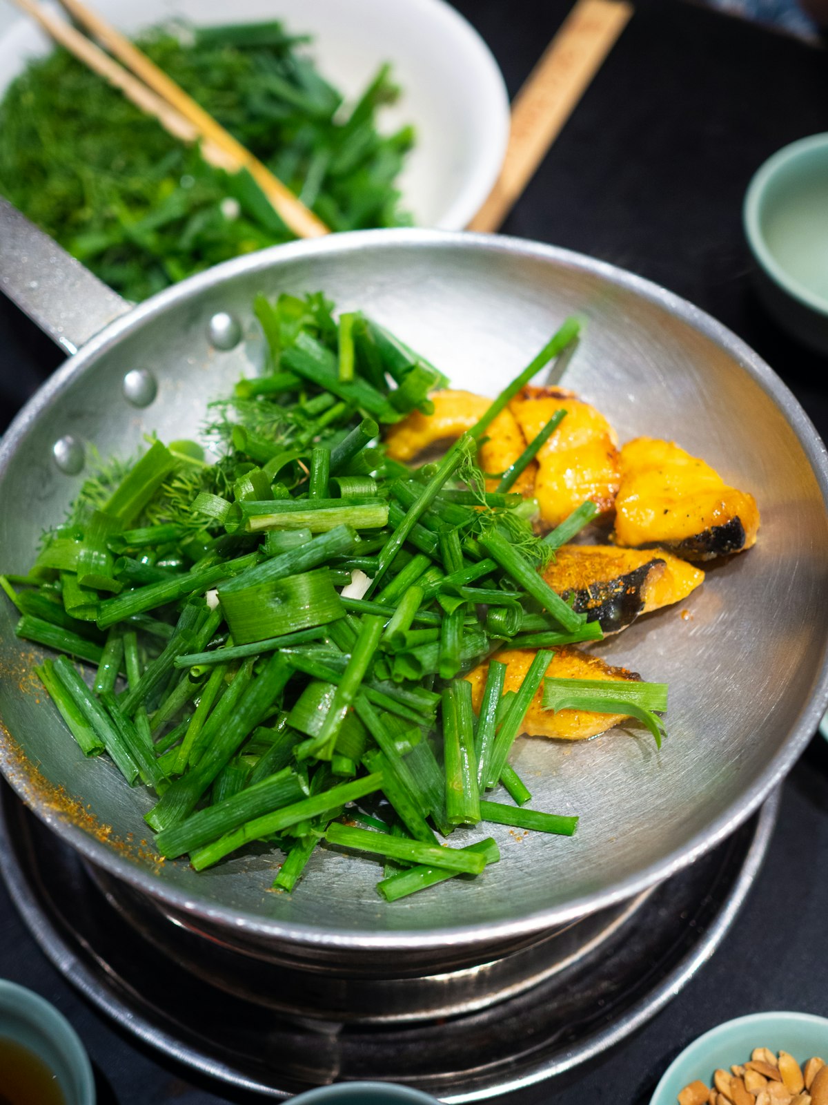 Peixe com legumes frescos sendo preparado na frigideira